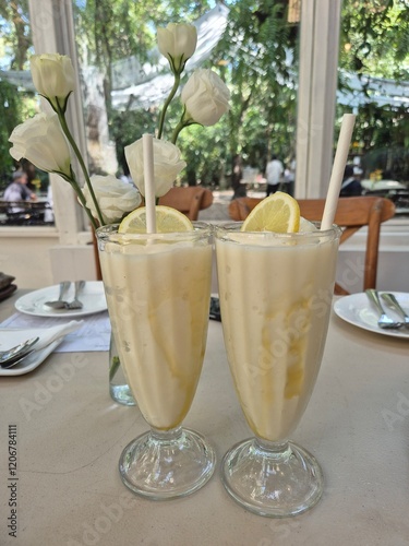 Coconut smoothie topping with fresh  herbal fruit and filling with organic honey syrup serving in the glass. Famous refreshment cold beverage drink menu in Asia restaurant. 