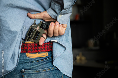 Personal weapons for self-defense. street crime concept. a man robs on the street. The search of the criminal, the man pulls a gun out of his jeans. Death threat. photo