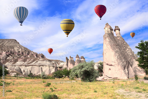 The balloon flight, famous tourist attraction of Cappadocia. Air balloons and Fairy Chimney (multihead stone mushrooms) in Pasabag Valley, Cappadocia, Anatolia, Turkey photo