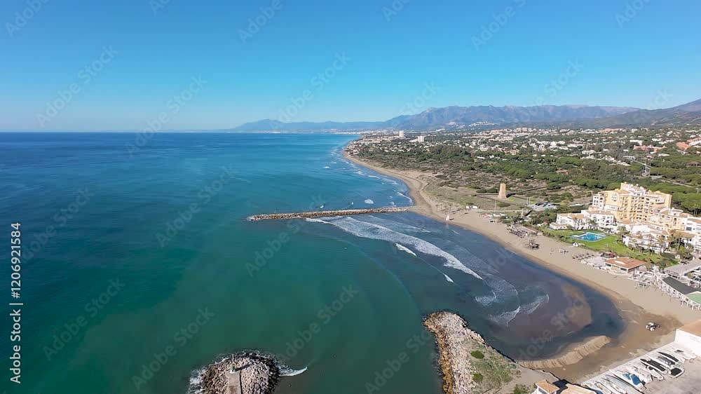 Aerial drone footage of the beautiful beach front in the Spanish town of Calahonda showing the Cabopino Marina in Marbella Spain and the Cabopino Beach on a bright sunny day