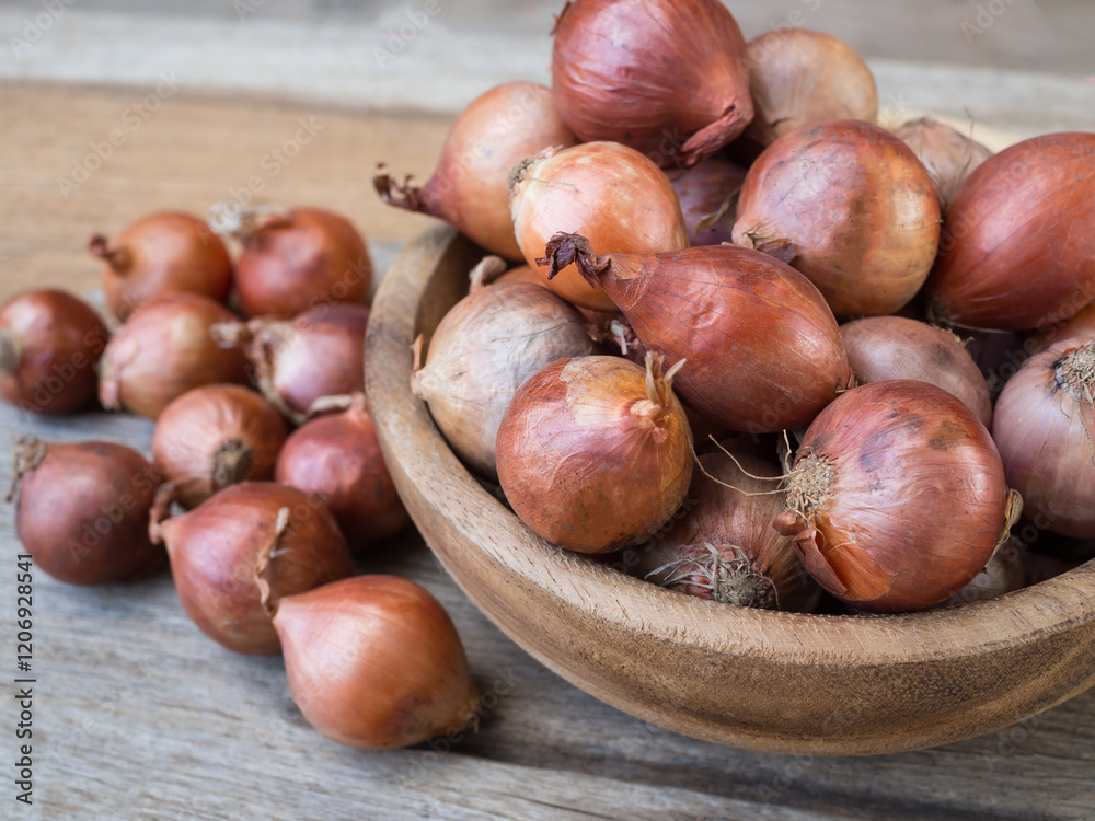 Shallots in a wood bowl on wooden background. Shallots in a wood bowl on wooden background.