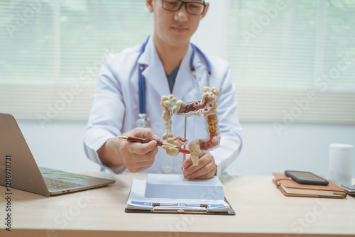 Male doctor treating intestinal diseases at a hospital table, discussing intestinal disease models, diagnosing gastritis ileitis,appendicitis, colon cancer,providing treatment plans and patient care photo