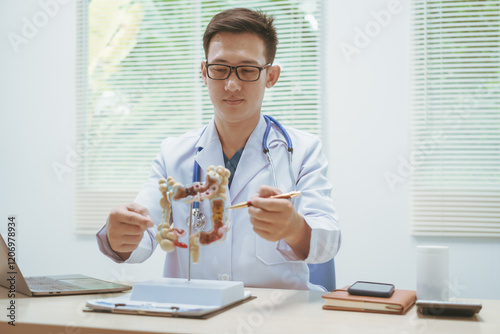 Male doctor treating intestinal diseases at a hospital table, discussing intestinal disease models, diagnosing gastritis ileitis,appendicitis, colon cancer,providing treatment plans and patient care photo