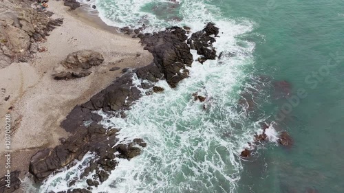 A stunning top-down drone view of Spain’s Mediterranean coastline, featuring turquoise waters, rugged rocks, and crashing waves. A breathtaking perspective of nature’s beauty. photo