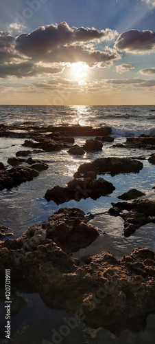 Relaxing sea waves at sunset near rocky coast