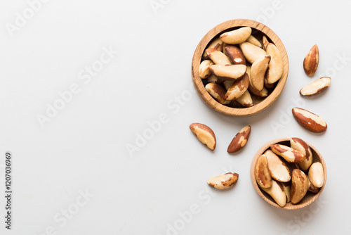 Fresh healthy Brazil nuts in bowl on colored table background. Top view Healthy eating bertholletia concept. Super foods photo