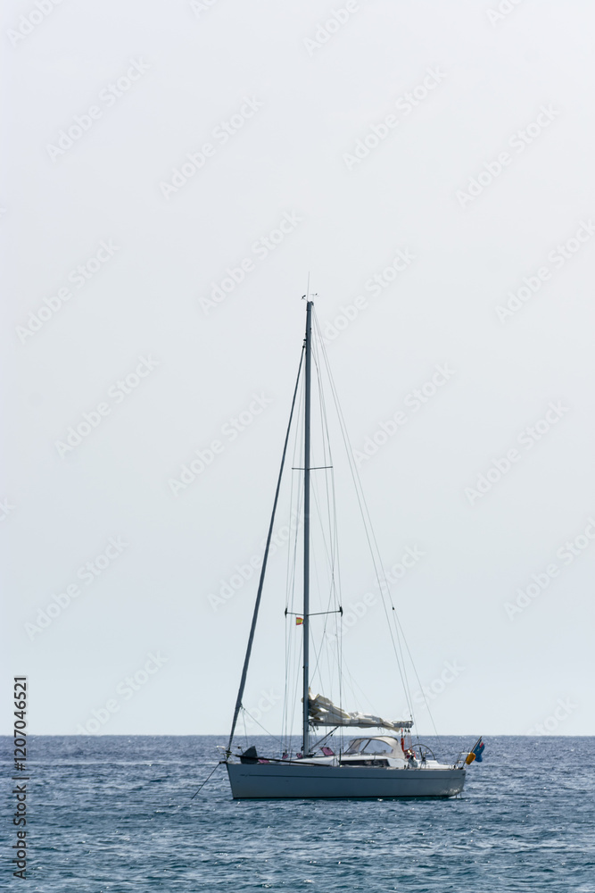Obraz premium nearby sailing ship anchored in calm sea on bright day