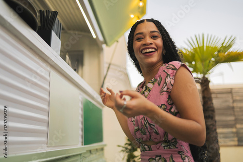 Happy woman standing near food truck