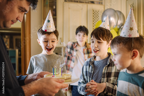 Brothers looking at cake held by father at home photo