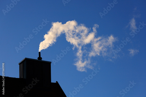 Smoke emitting from chimney under clear blue sky