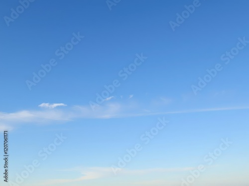 A tranquil blue sky with a few wispy stratus clouds stretching across the horizon, textured, peaceful, stratus clouds