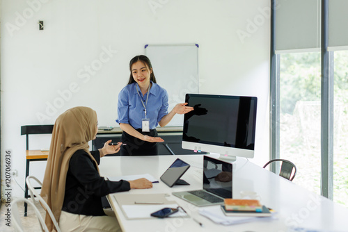Wallpaper Mural Young businesswoman adviser standing in front of laptop and giving advise to sales woman. Business people consulting at office. asian teamwork concept.
 Torontodigital.ca