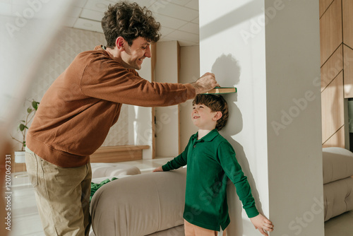 Father measuring son's stature at home