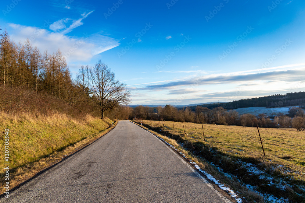 A paved road in the countryside. A cold, winter evening