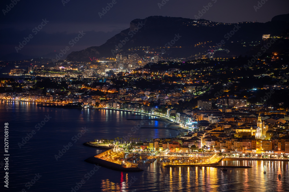 Night view on French Riviera, lights of Menton old city and marina on blue Mediterranean Sea near French-Italian border, Monaco, Monte-Carlo, travel destination, panoramic view Night view on French Riviera, lights of Menton old city and marina on blue Mediterranean Sea near French-Italian border, Monaco, Monte-Carlo, travel destination, panoramic view