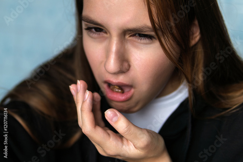 girl spits in her hand without biting the food. Vomiting and nausea.