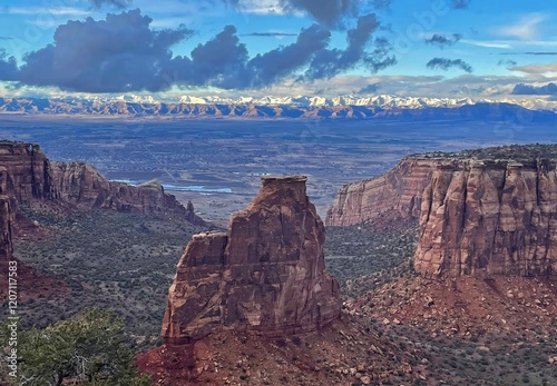  a dramatic vista on a sunny spring day over independence monument and the snowy  book cliffs in colorado national monument, fruita, colorado     photo