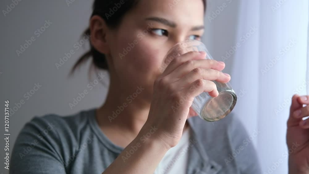 Asian pregnant woman is taking pills and vitamins for pregnant women with capsule on her hand and water. Drinking a tablet with a glass of water. Asian pregnant woman is taking pills and vitamins for pregnant women with capsule on her hand and water. Drinking a tablet with a glass of water.