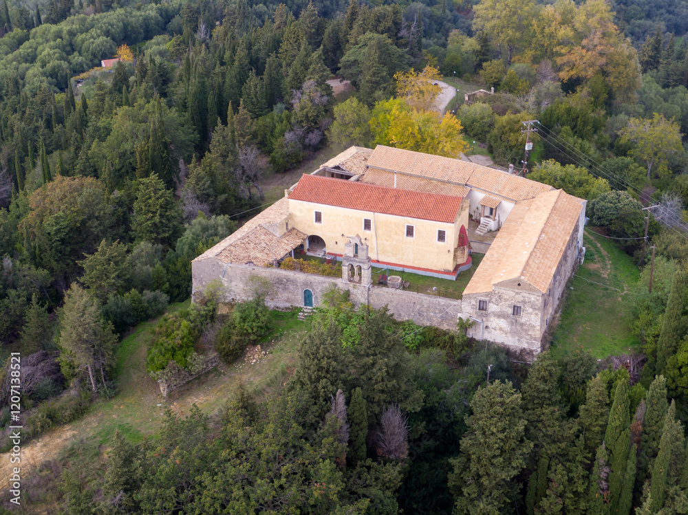 Aerial view of a secluded stone building complex nestled within a lush forest. Aerial view of a secluded stone building complex nestled within a lush forest.