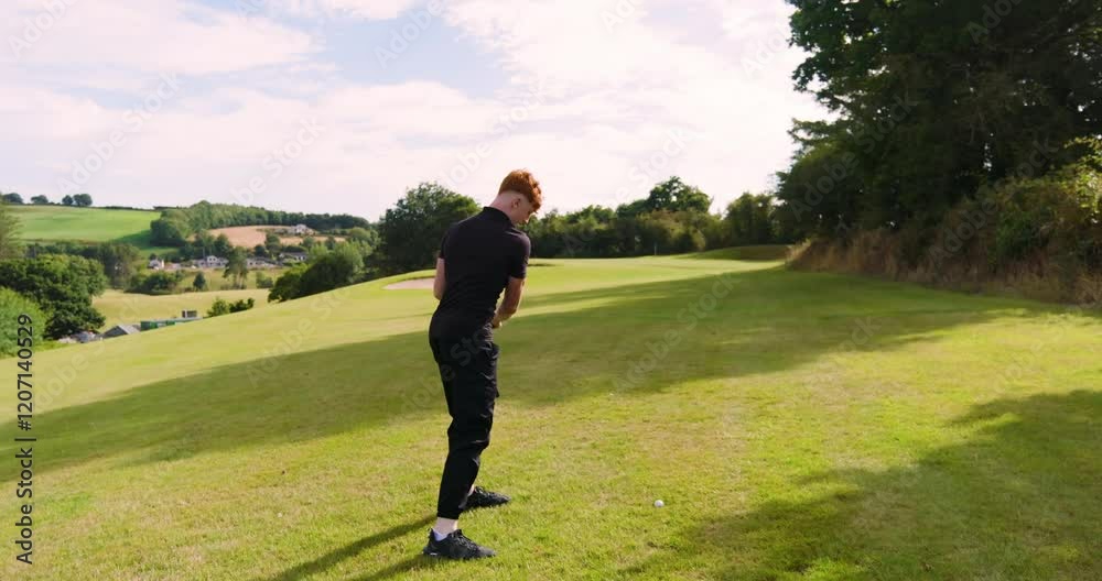 Male golf player playing golf, hitting the ball with club on a golf course on a sunny day Male golf player playing golf, hitting the ball with club on a golf course on a sunny day