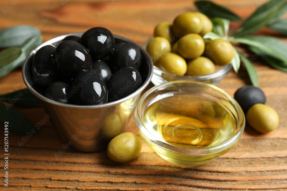 Bowl of fresh olive oil and olives with leaves on the table Bowl of fresh olive oil and olives with leaves on the table
