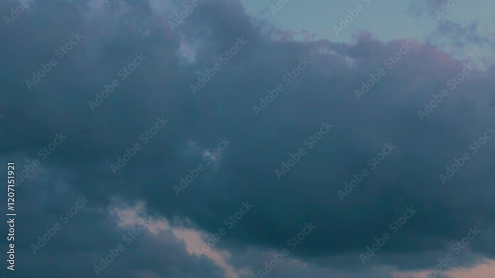 Black gray rain cumulus clouds in blue orange sky in sunlight sunset time lapse slow motion. Tropical storm, clouds and colorful evening sky, beautiful atmospheric rain cloud skyscape background.
