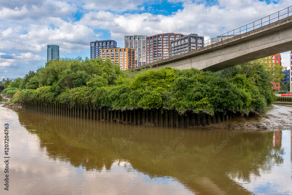 Bow Creek with modern apartments buildings in the background, showcasing the dynamic urban landscape of East London Bow Creek with modern apartments buildings in the background, showcasing the dynamic urban landscape of East London