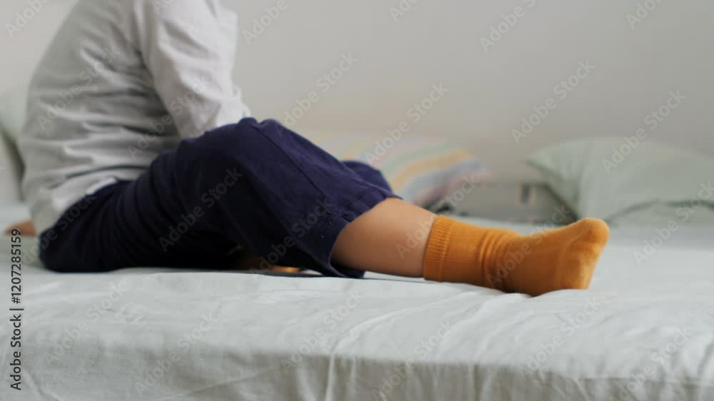 Mother rolling up her child into a soft blue blanket and unrolling him playfully Mother rolling up her child into a soft blue blanket and unrolling him playfully