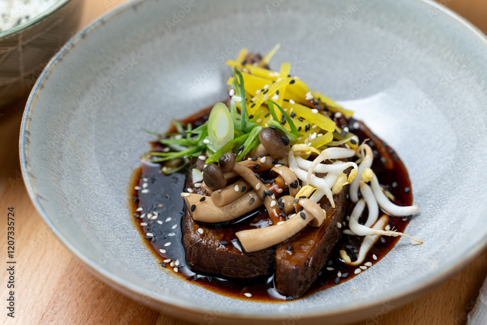 modern cooking restaurant beef cheeks fillet stew mushroom shitake chilli garnish brown sauce bowl wooden table detail
