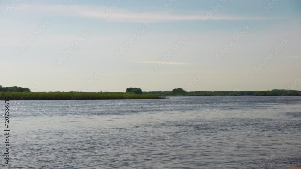 The Mississippi flows through green banks in fading Midwestern sunshine. The Mississippi flows through green banks in fading Midwestern sunshine.