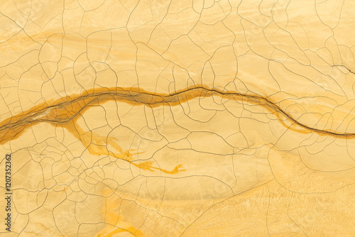 Golden mud and cracked earth texture for abstract backgrounds photo