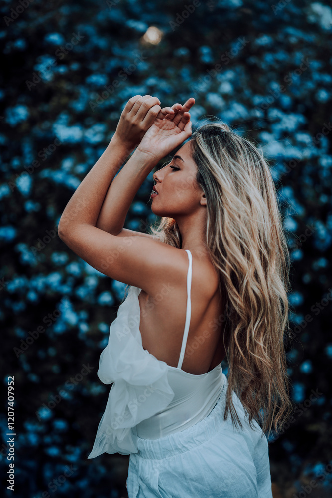 Chica rubia joven posando frente a cámara en jardin urbano