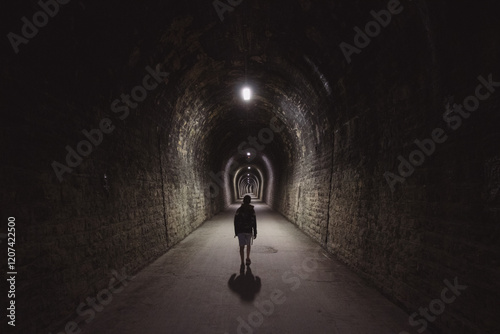 silhouette dans un long couloir, tunnel sombre et obscur photo