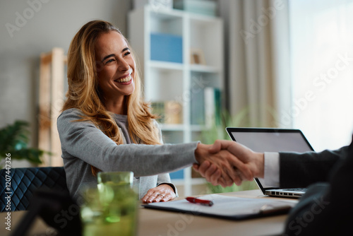 Happy businesswoman shaking hands with businessman after closing a deal in the office