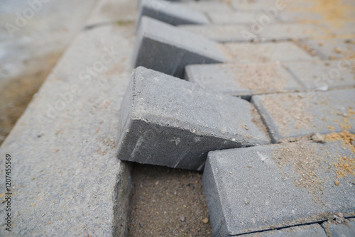 Paving slabs closeup. Laying tiles along the sidewalk curb and border, preparing the road for completion with high-quality paving slabs and precise installation.