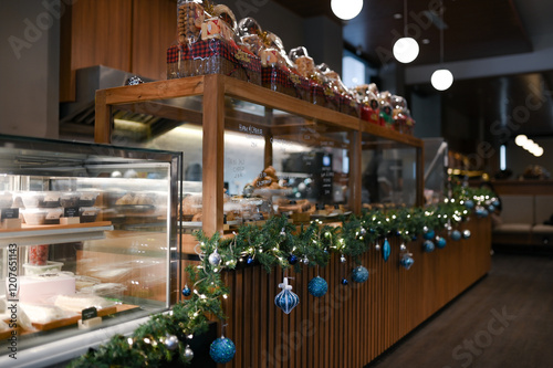 Christmas decoration for restaurant, shopping mall, retail store, grocery with blue and white glass spheres, leafy plants arrangement and chain lights on the display photo
