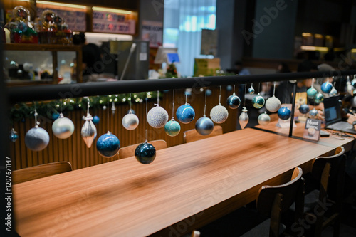 Christmas decoration for restaurant, shopping mall, retail store, grocery with blue and white glass spheres, leafy plants arrangement and chain lights on the display photo