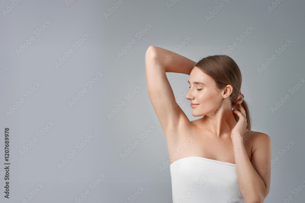 Young beautiful woman show smooth shaved armpits on grey color background with copy space. Laser epilation, electroepilation Young beautiful woman show smooth shaved armpits on grey color background with copy space. Laser epilation, electroepilation