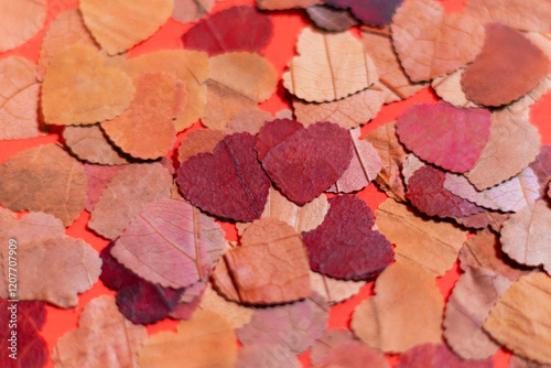 Eco heart-shaped confetti from leaves on red background.