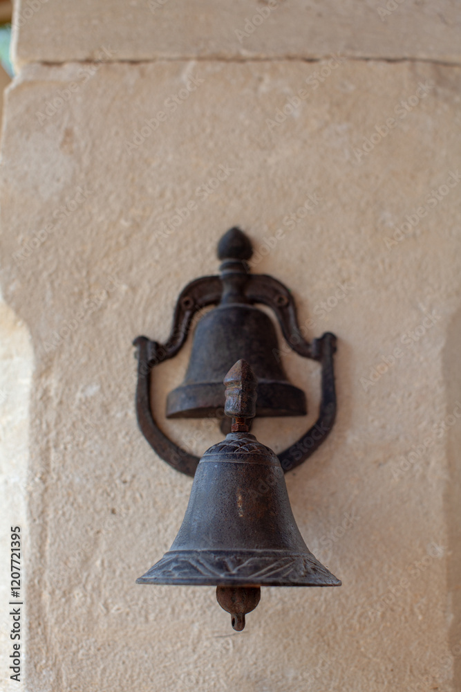 Obraz premium Old bronze bell on the wall of a church in Provence, France