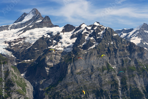 Paragliders at First mountain with Schreckhorn mountain in the background, Jungfrau Region, Bernese Oberland, Switzerland photo