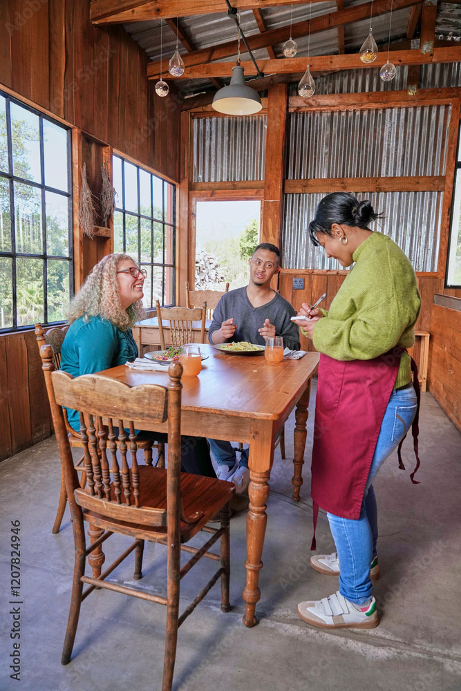 Waitress taking order from man and woman sitting at table in restaurant Waitress taking order from man and woman sitting at table in restaurant
