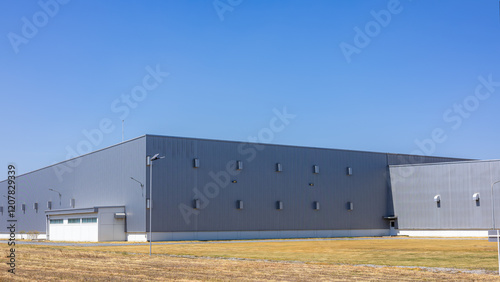 Modern Industrial Warehouse Exterior on a Sunny Day, Factory industry, Warehouse Construction in Geometric Modern Design, Backdrop Wall Metal Corrugated Steel Surface Pattern. photo