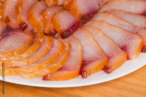 Sliced different cold smoked freshwater fish on plate, close-up photo