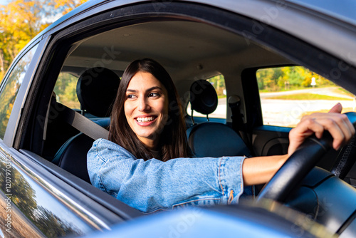 Photos The woman, smiling, drives with the steering wheel on the right side of the car,