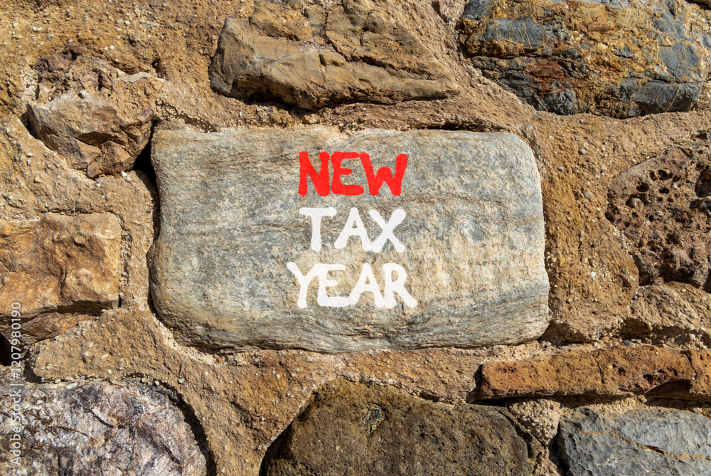 New tax year symbol. Concept words New tax year on beautiful grey stone on stone wall. Beautiful stone wall background. Business new tax year concept. Copy space. New tax year symbol. Concept words New tax year on beautiful grey stone on stone wall. Beautiful stone wall background. Business new tax year concept. Copy space.