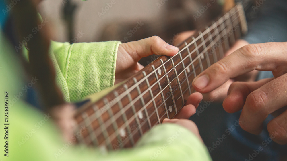 Fototapeta premium Playing a musical instrument. Father teaching daughter to play electric guitar. Close up