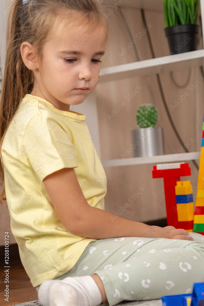 Little girl playing with colorful toy blocks in room at home. Little girl playing with colorful toy blocks in room at home.