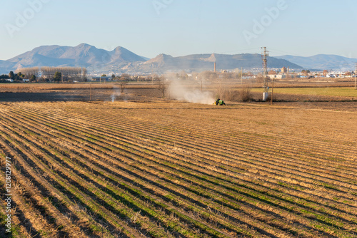 Vista de la vega de Granada con un tractor arando la tierra photo