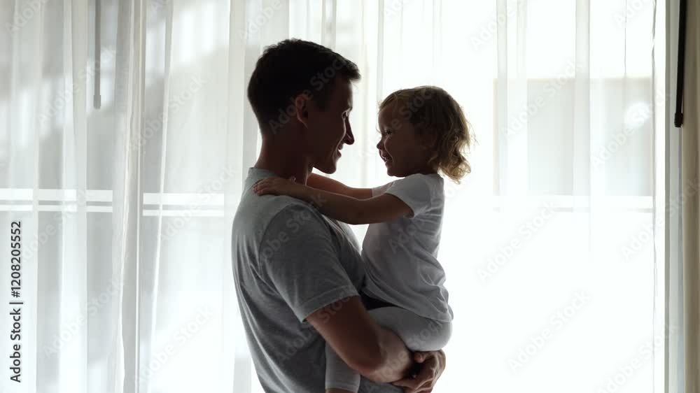 Father holding his daughter by the window in hotel room Father holding his daughter by the window in hotel room